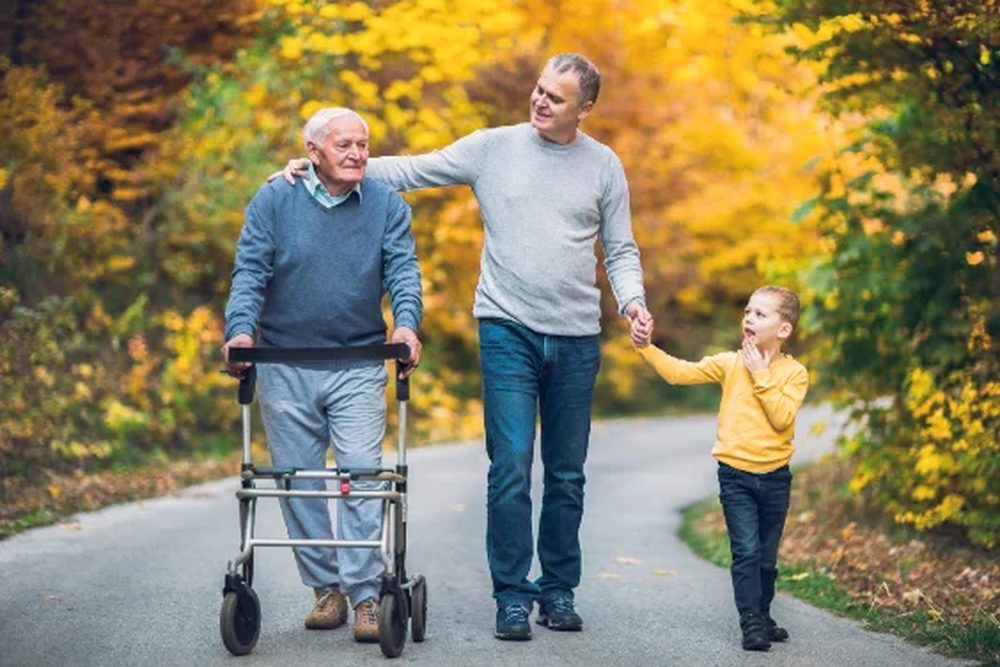 Three generations of a family walking together on an autumn path